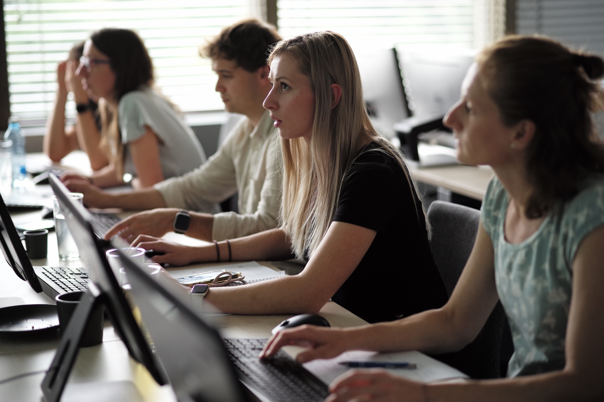 Účastníci letní školy pracují u laptopů